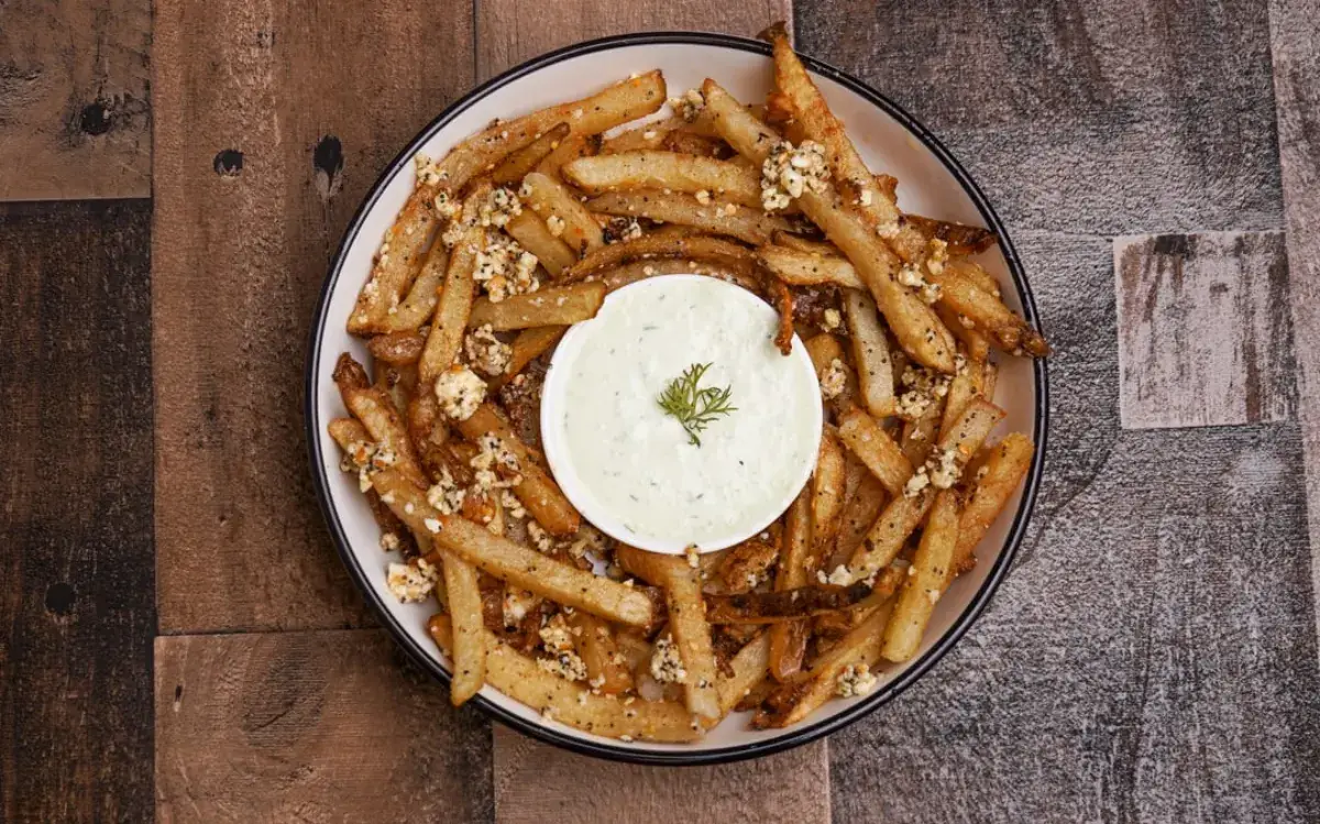 Greek fries topped with feta and a cup of garlic dip