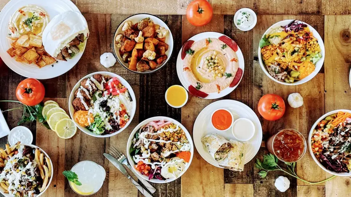 A family meal spread of rice, chicken, hummus and salads