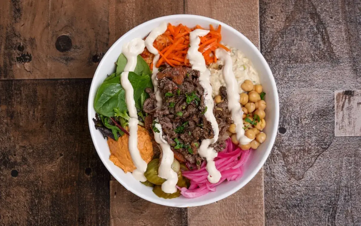 Gyro bowl with greens, chickpeas, carrots, red pepper hummus and tzatziki